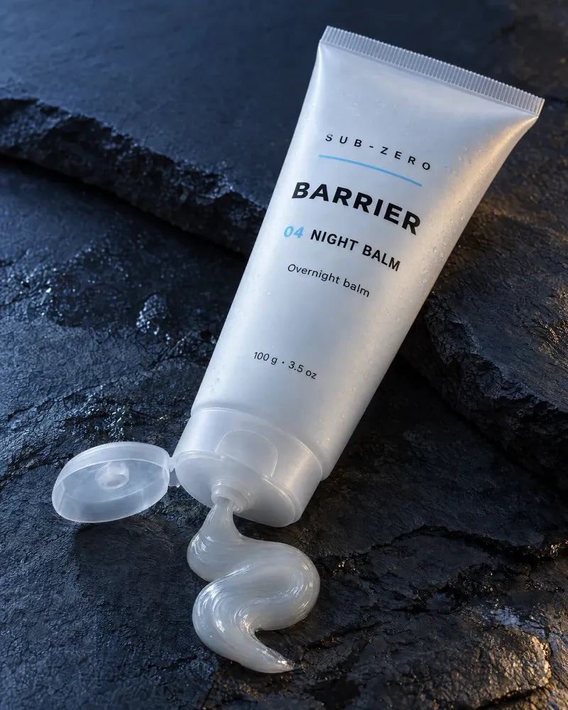 The Night Balm tube with a ribbon of balm on slate