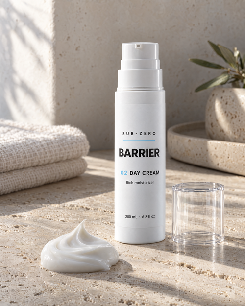 Dollop of BARRIER Day Cream rich moisturizer on travertine beside the airless bottle
