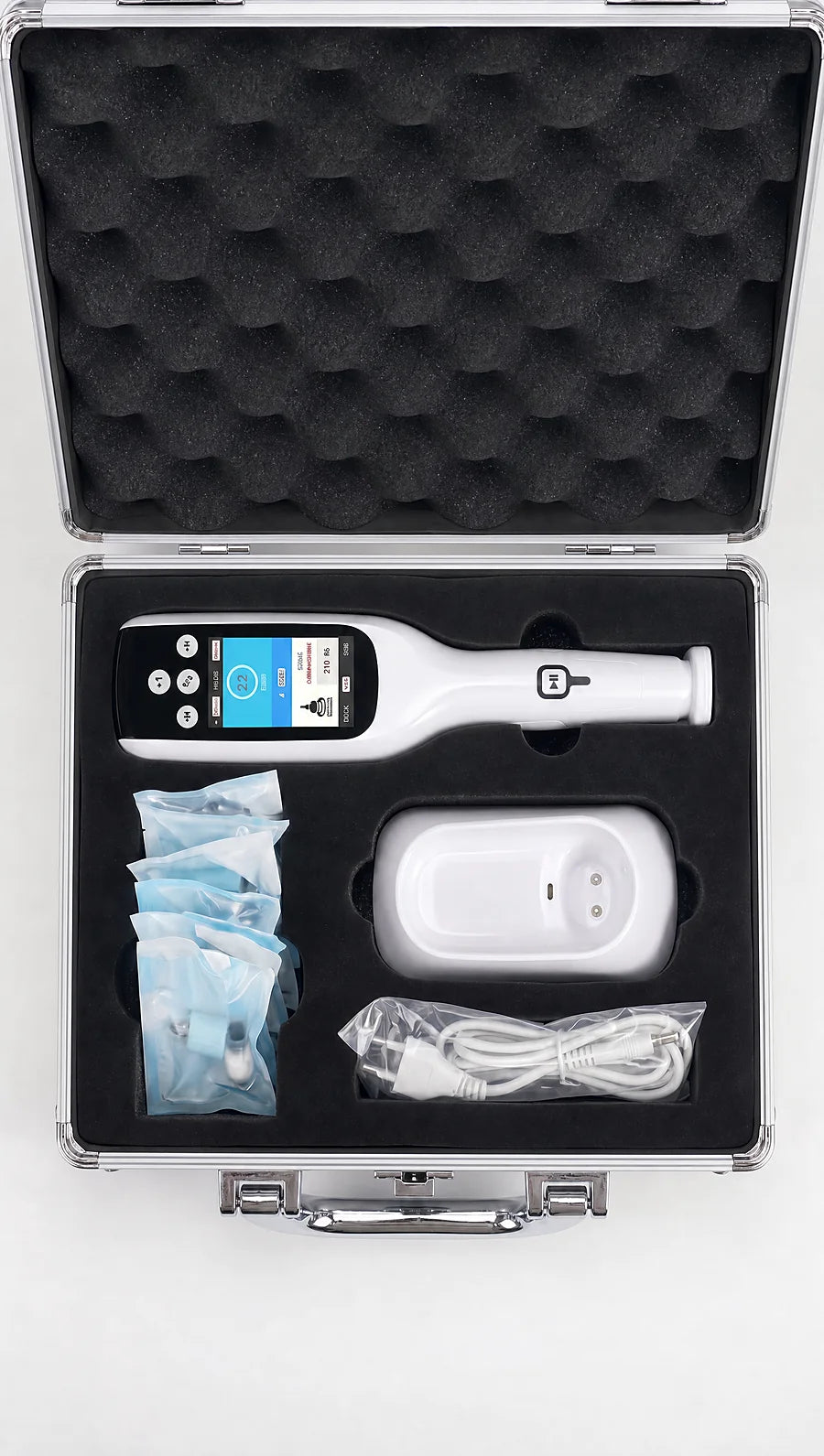Apex aluminium case from above — device, charging stand, treatment heads and cable in cut foam